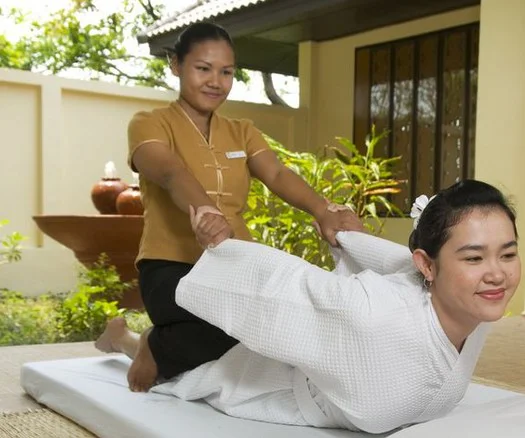 woman being stretched by Thai massage therapist